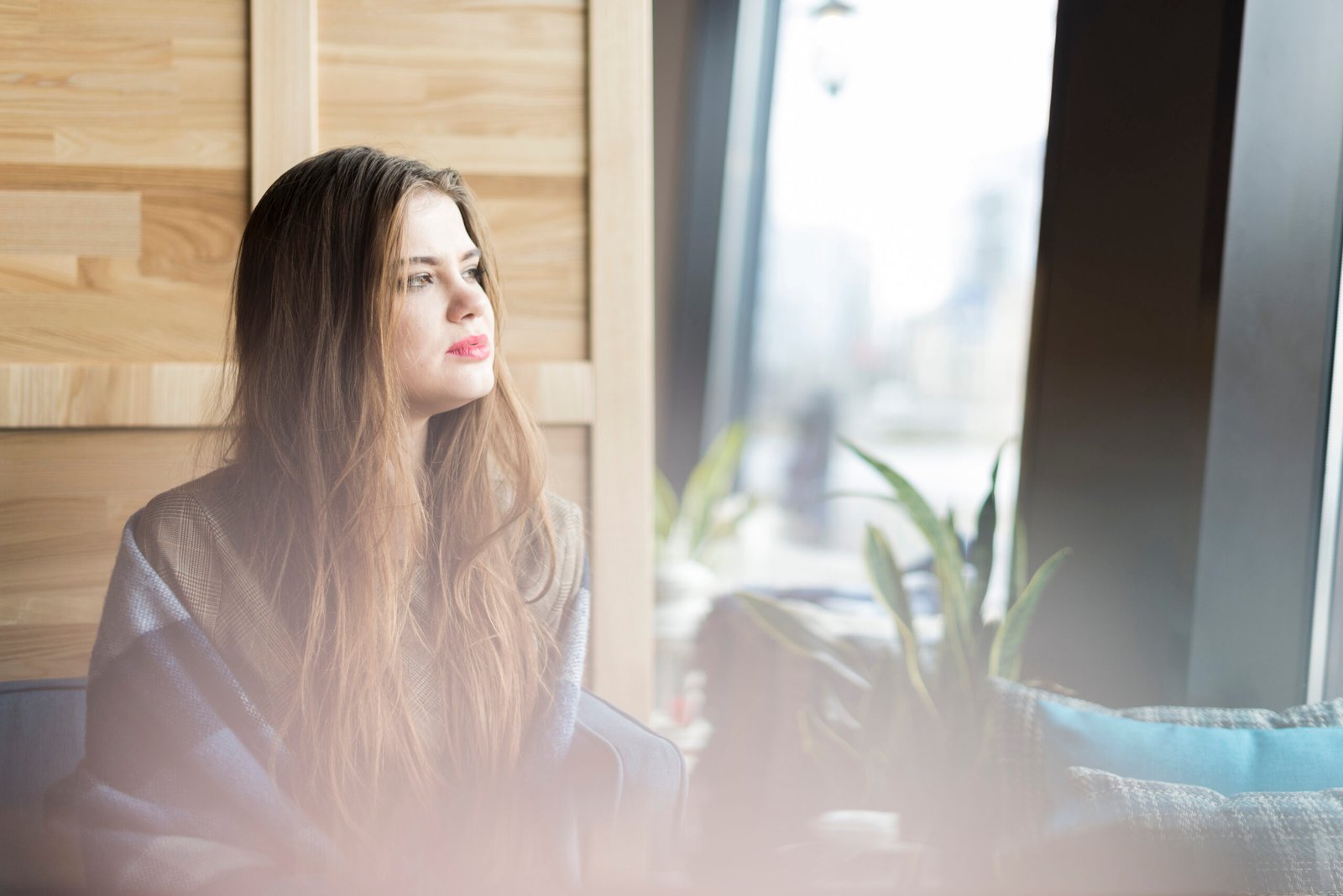 Mujer pensativa mirando por la ventana tras una crisis de ansiedad